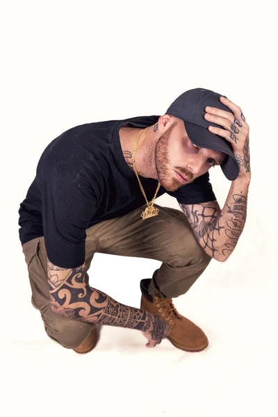 Tatuato Cantante Rap Posa Studio Indossando Vestiti Neri Uno Sfondo — Foto Stock