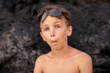 funny portrait of young shirtless man wearing sunglasses in an exotic beach - summer vacation concept