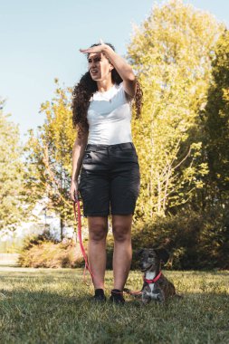 Güzel bayan köpek eğitmeni köpeğini açık hava parkında eğitiyor. Hayvanlara karşı sevgi kavramı.