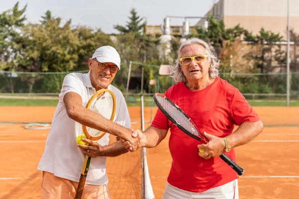 Portré Két Idősebb Teniszezőről Sportruházatban Kezet Rázva Egy Salakos Teniszpályán — Stock Fotó