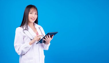 Sağlık teknolojisi konsepti. Profesyonel eczacı, doktor ya da hemşire kadın, laboratuvar önlüğünü steteskop ile giyerken, izole edilmiş mavi arka planda dururken, eczane tıbbi tableti kullanıyorlar..