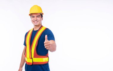 Bakım işçisi mesleği konsepti. Yakışıklı, kendine güvenen bir zanaatkar, sarı başlık takar, sıkı kaskı takar, iyi bir iş için baş parmağını kaldırır ve izole beyaz arka planda durur..