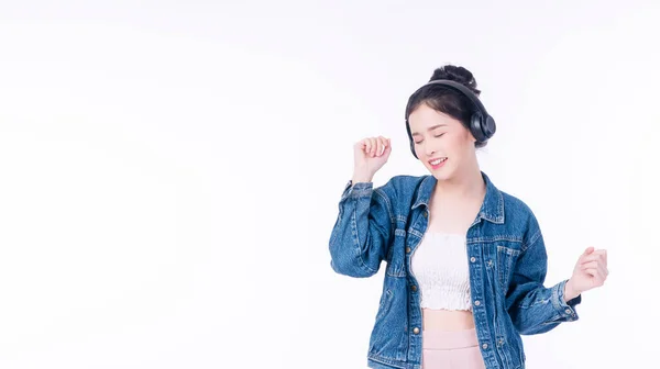快乐的亚洲女人使用无线耳机听音乐 喜欢在与世隔绝的白色背景下轻松地跳舞 亚洲青少年的耳机 站在白色的背景音乐休息 — 图库照片