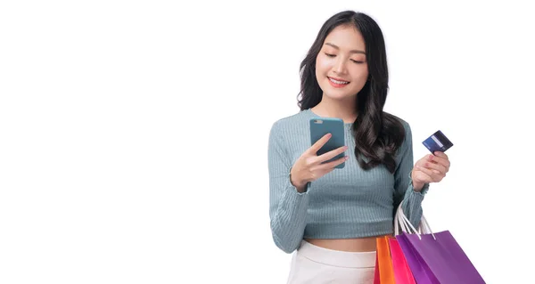 Ενθουσιασμένος Χαμόγελο Ασιατική Γυναίκα Ψάχνει Κινητό Τηλέφωνο Κρατώντας Τσάντα Ψώνια — Φωτογραφία Αρχείου