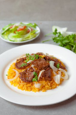 Vietnamese Shaking Beef, salad,  bowls, and plates with food top view