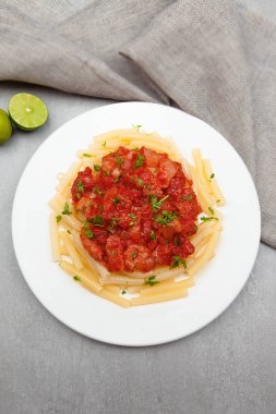 Pasta tomato sauce, owls, and plates with food top view