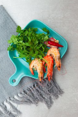 Boiled shrimp, coriander, pickled onion, owls, and plates with food top view