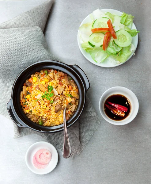Chinese fried rice, salad, spice, bowls, and plates with food top view   