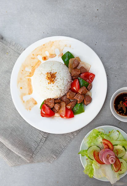 Vietnamese Shaking Beef, salad,  bowls, and plates with food top view