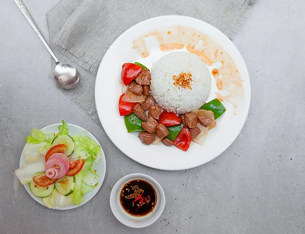 Vietnamese Shaking Beef, salad,  bowls, and plates with food top view
