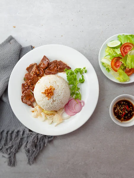 Vietnamese Shaking Beef, salad,  bowls, and plates with food top view