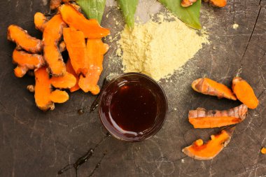 Turmeric powder and a glass of honey are isolated on old rustic wood table backgrounda beauty and spa concept.