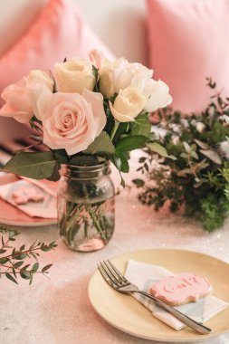 Basket of roses on the table at the party, Party decoration cupcakes, fruit mixes, candies