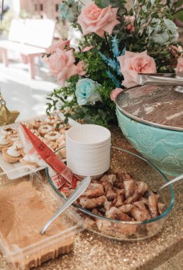 Basket of roses on the table at the party, Party decoration cupcakes, fruit mixes, candies