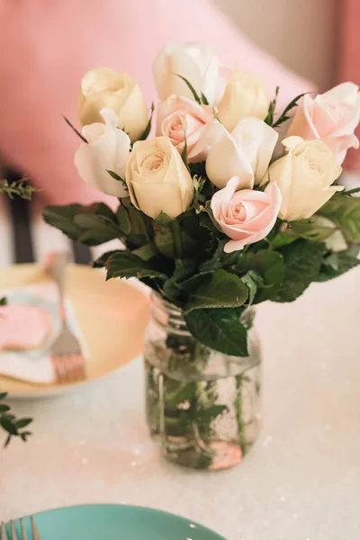 Basket of roses on the table at the party, Party decoration cupcakes, fruit mixes, candies