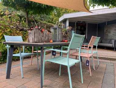 Apeltern, Hollanda, 12 Ekim 2022: Appeltern Hollanda 'nın en büyük bahçe fikri parkı. Tenteli, bahçe sandalyeli ve ahşap masalı kış terası. Masanın üzerinde Noel kompozisyonu