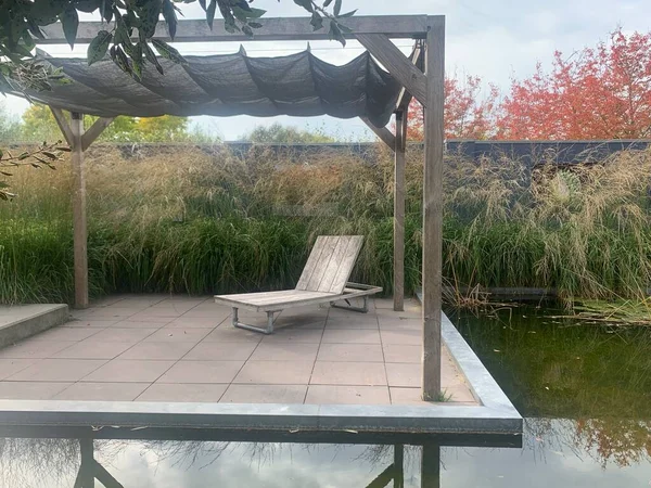 Apeltern, Hollanda, 12 Ekim 2022: Appeltern Hollanda 'nın en büyük bahçe fikri parkı. Nehir manzarası ve parkta göl manzarası çok güzel. Büyük teras ve güverte sandalyesi Sonbaharda su kenarında Nehir manzarası ve parktaki göl manzarası