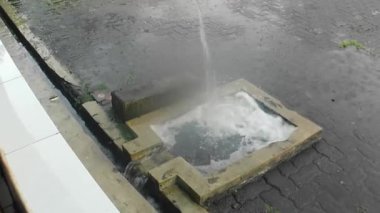 Yağmur mevsimi, cami otoparkındaki kaldırımlı yola damlayan yağmur damlaları. 4K görüntü kalitesi.