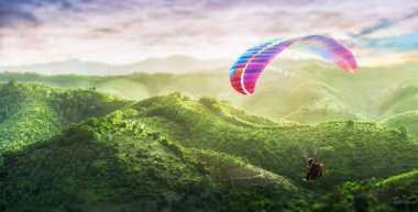 Paragliding multicolor. Paraglider flying over Landscape from the background Beauty nature mountain landscape of the sky. Paragliding Sports. Concept of extreme sport, taking adventure/ challenge.
