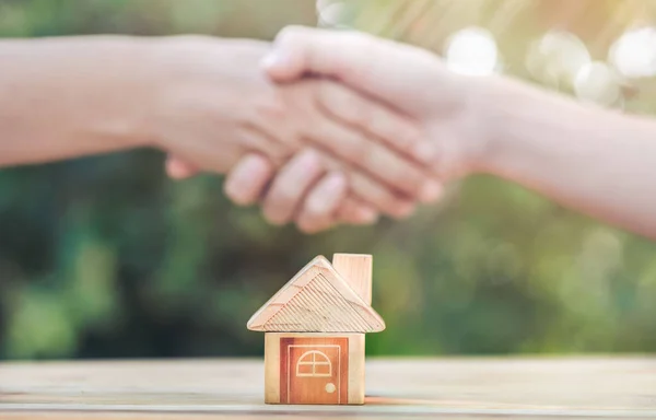 Real estate brokers and clients shake hands after agreeing to buy a home. realty purchase, Bank employees congratulate, Concept mortgage loan approval. planning savings money of coins to buy a home.
