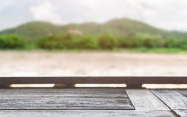 Dağ manzaralı ahşap masa üstü. Ahşap masa, dağ manzarası ve boş ekran. Montajınız için boşluk.