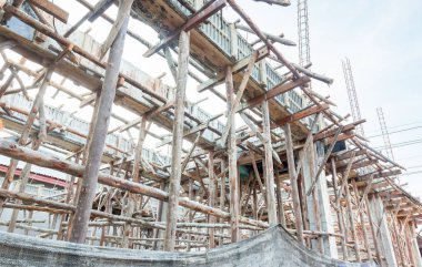 İnşaat alanı, binayı güçlendirmek için çimento dökme adımları. Gökyüzü zemininde inşaat için çelik ve ahşap yapı. 