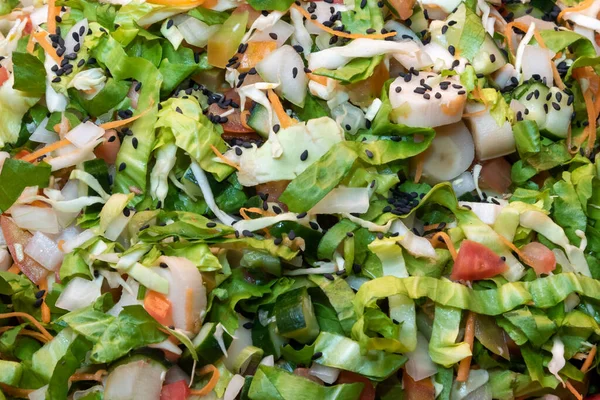Salad mix with lettuce, hearts of palm, tomatoes, cucumbers, carrots and sesame seeds