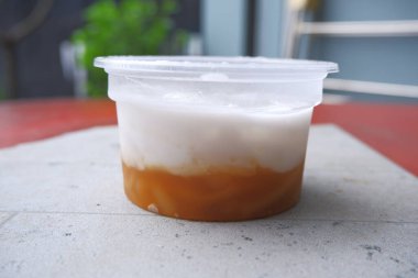 Thai pudding with coconut topping , in a cup.