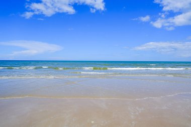 Deniz kıyısında deniz dalgaları kıyıya çarpıyor ve güzel gökyüzü ve bulutlar.