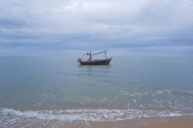 Balıkçı tekneleri kumların ve dalgaların olduğu sahilde duruyor..