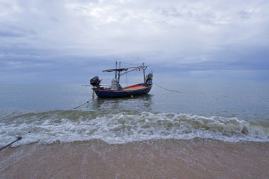 Balıkçı tekneleri kumların ve dalgaların olduğu sahilde duruyor..