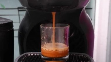 Otomatik kahve makinesi espresso shot 'ı yapıyor. Kremalı kahve suyu güzel bir altın rengi ve çok güzel bir koku verir..