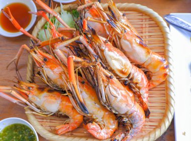 Izgara Büyük Nehir Karidesi. Salatalık ve marulla süslenmiş bambu bir tabağa yerleştirilmiş..