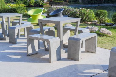 Dışarıda çimentodan yapılmış masa ve sandalyeler.