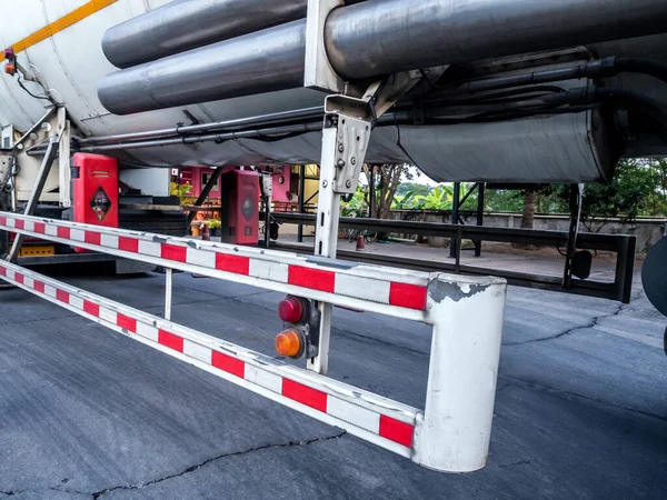 Red and white striped sign on side guard of the tanker truck