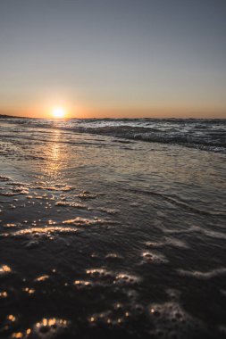 Waves of the sea surf on the background of the sunset
