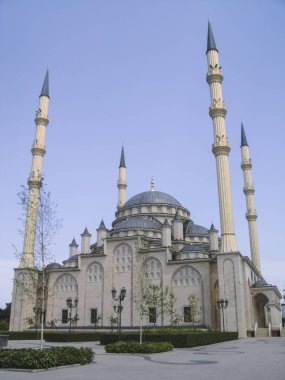 Mavi gökyüzüne karşı dört minaresi ve gri kubbeleri olan beyaz mineral camii restore edildi.