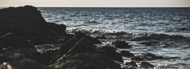 Karadeniz 'in gel-git dalgaları kayalık kıyılara ve taşlara vurarak sıcak bir yaz gününde, tuzlu su damlaları ve sıçramalar yaratıyor.