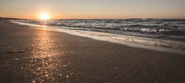 Sıcak bir yaz günbatımının panoramik manzarası Karadeniz kıyısında şiddetli dalgalarla, sıcak bir yaz akşamıyla