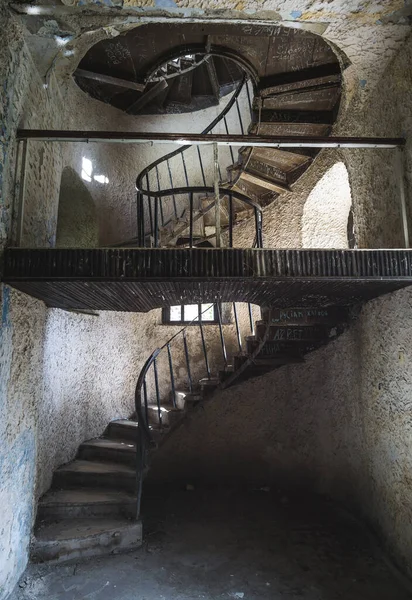 Old spiral staircase in an ancient castle with old metal structures and low lighting, in an ancient castle from old times