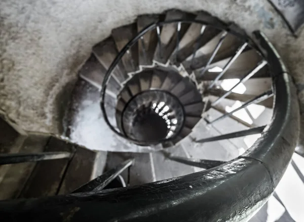 Old spiral staircase in an ancient castle with old metal structures and low lighting, in an ancient castle from old times