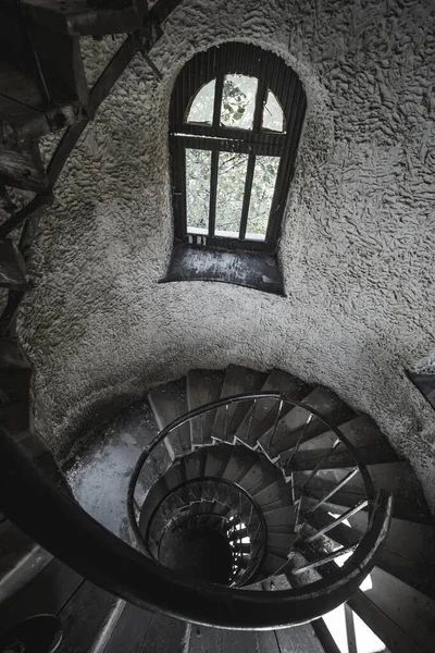 Old spiral staircase in an ancient castle with old metal structures and low lighting, in an ancient castle from old times