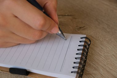 Taking note, a woman taking notes in the notebook.