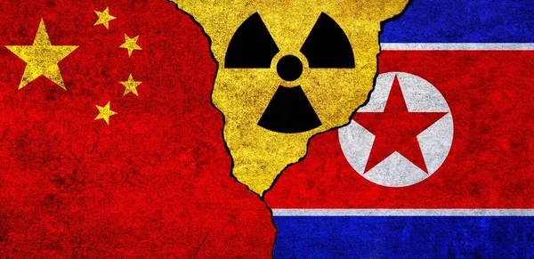 Flags of North Korea, China and radiation symbol together. China and North Korea Nuclear deal, threat, agreement, tensions concept