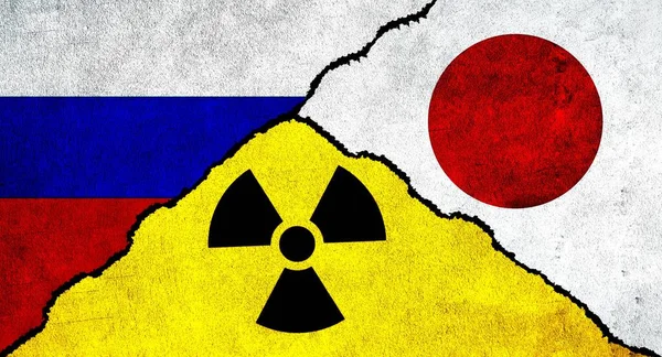 Flags of Russia, Japan and Nuclear symbol together on textured wall