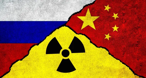 Flags of Russia, China and Nuclear symbol together on textured wall