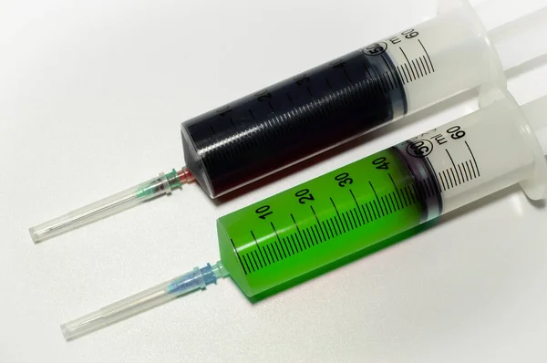 白い背景に血液と緑の色のワクチンを持つ2つの医療用注射器 そうだ 高品質の写真 — ストック写真