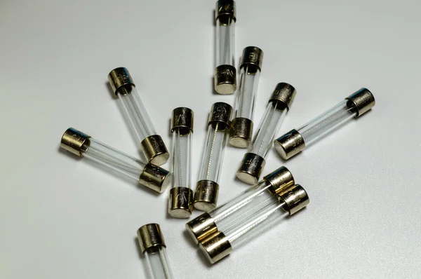 Small pile of clear electrical fuses on a white background. Set of glass fuses with filament inside. . High quality photo