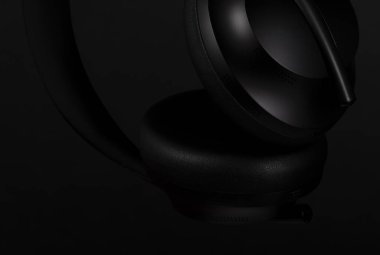 Siyah arka planda siyah kulaklıkların yakın plan görüntüleri.