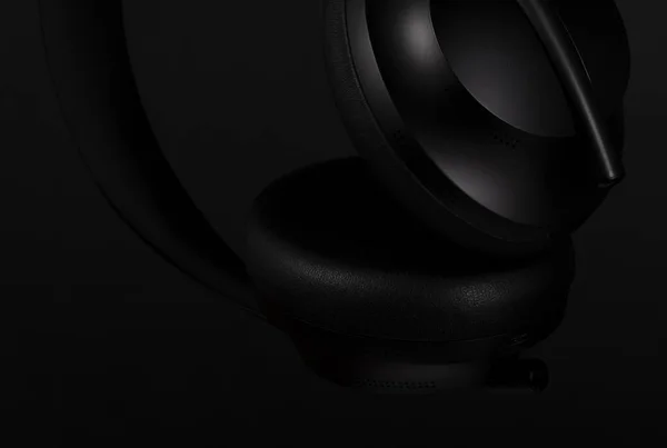 Siyah arka planda siyah kulaklıkların yakın plan görüntüleri.